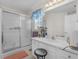 Bright bathroom with vanity, stool, shower with glass doors and decorative window valance at 507 Mockingbird Ln, Loganville, GA 30052