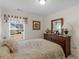 Charming bedroom with a bed, dresser, and a window with blinds and valance at 507 Mockingbird Ln, Loganville, GA 30052