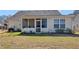 Home's back exterior shows a screened porch, window, manicured landscaping, and grass at 507 Mockingbird Ln, Loganville, GA 30052