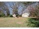 View of the backyard with two sheds and a stone firepit at 70 Oaklake Dr, Covington, GA 30016