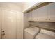 Laundry room with white appliances, storage cabinets, and easy access at 70 Oaklake Dr, Covington, GA 30016