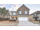 Charming two-story home featuring a brick and stone facade, a two-car garage, and a well-manicured front lawn at 125 Sunland Blvd, Mcdonough, GA 30253