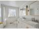 Bright bathroom featuring double sinks with marble countertops, white cabinets, and stylish fixtures at 1989 Mount Vernon Rd, Atlanta, GA 30338
