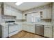 Bright eat-in kitchen features white cabinets, stainless steel dishwasher and hardwood floors at 1989 Mount Vernon Rd, Atlanta, GA 30338