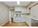 White kitchen with stainless steel dishwasher, white cabinetry and hardwood floors at 1989 Mount Vernon Rd, Atlanta, GA 30338