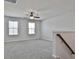 A versatile bonus room with carpet, ceiling fan, and two large windows, perfect for relaxing or entertaining at 220 Eastmark Way, Fayetteville, GA 30214