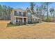 Side view of a two-story brick home featuring professionally landscaped front yard at 220 Eastmark Way, Fayetteville, GA 30214