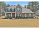 Charming two-story brick home with a covered porch and professionally landscaped front yard at 220 Eastmark Way, Fayetteville, GA 30214