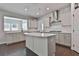 Bright kitchen features white cabinets, stainless appliances, a kitchen island, and hardwood floors at 220 Eastmark Way, Fayetteville, GA 30214