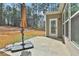 Concrete patio area has an umbrella and overlooks the backyard lawn and wooded area at 220 Eastmark Way, Fayetteville, GA 30214