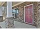 Inviting front porch of a brick home with stone accents and white columns at 220 Eastmark Way, Fayetteville, GA 30214