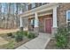 Inviting front porch of a brick home with stone accents and white columns at 220 Eastmark Way, Fayetteville, GA 30214