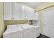 Functional laundry room equipped with washer, dryer, and ample storage cabinets at 3015 Foxhall Overlook, Roswell, GA 30075