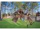 A wooden playground set is nestled in the spacious backyard, perfect for Gathering fun at 3015 Foxhall Overlook, Roswell, GA 30075