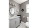 Bright bathroom with marble countertop vanity, updated lighting and fixtures, and tiled floor at 974 Grant Se St, Atlanta, GA 30315