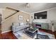Comfortable living area with hardwood floors, a gray sofa, and a large TV at 974 Grant Se St, Atlanta, GA 30315