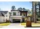 Modern two-story home with a glass garage door and professionally landscaped front yard at 1051 Wimberly Ne Rd, Brookhaven, GA 30319