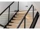 Close up of wooden stairs with black railing and glass panels, enhanced by subtle LED lighting for a modern touch at 1051 Wimberly Ne Rd, Brookhaven, GA 30319