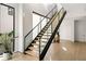 Modern staircase with wood treads, black railing, glass panels, and light wood floors creates a bright and airy space at 1051 Wimberly Ne Rd, Brookhaven, GA 30319