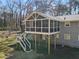 A gray home featuring a spacious screened porch with a white railing overlooking the backyard at 1300 Valley Ct, Roswell, GA 30075