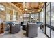 Relaxing sunroom featuring brick walls, stone floors, and comfortable seating at 1358 Magnolia Path Way, Sugar Hill, GA 30518