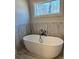 Luxurious bathroom featuring a freestanding tub and accent tiled wall at 224 Crest Creek Way, Villa Rica, GA 30180