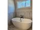 Modern bathroom with freestanding tub, tile surround, and natural light at 224 Crest Creek Way, Villa Rica, GA 30180
