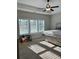 Bright bedroom featuring a tray ceiling, ceiling fan, and large windows at 224 Crest Creek Way, Villa Rica, GA 30180