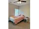 Bedroom features neutral walls, a ceiling fan, and a bed with decorative pink comforter at 224 Crest Creek Way, Villa Rica, GA 30180