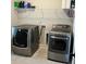 Laundry room features modern appliances, shelving, and grey tile flooring at 224 Crest Creek Way, Villa Rica, GA 30180