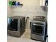 Modern laundry room features gray front load washer and dryer with storage shelf at 224 Crest Creek Way, Villa Rica, GA 30180