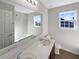 This bathroom features a bathtub with shower, double sink vanity, and a large mirror at 1182 Tupelo Chase Ct, Auburn, GA 30011