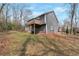 Exterior view of the rear of the home featuring a wooden deck and lush green lawn at 1575 Kelleys Close, Stone Mountain, GA 30088