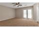 Spacious bedroom with neutral carpet, ceiling fan, and French doors at 1575 Kelleys Close, Stone Mountain, GA 30088