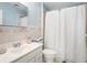 Well-lit bathroom with a modern sink, a toilet, and a shower with neutral tile surround at 320 Six Branches Ct, Roswell, GA 30076
