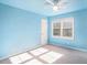 Bright bedroom features a ceiling fan, a large window providing natural light, and light blue painted walls at 320 Six Branches Ct, Roswell, GA 30076