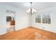 Dining room displaying hardwood floors and a chandelier, leading to kitchen and living area at 320 Six Branches Ct, Roswell, GA 30076