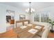 The dining room has hardwood floors and a modern chandelier above a table set for four at 320 Six Branches Ct, Roswell, GA 30076