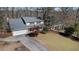 An elevated view of a yellow two-story home with a two-car garage and well-kept landscaping at 320 Six Branches Ct, Roswell, GA 30076