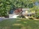 Traditional two-story home with a well-manicured lawn and a two car garage at 320 Six Branches Ct, Roswell, GA 30076