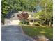 Traditional two-story house featuring an attached garage and a vibrant green lawn bordered by mature trees at 320 Six Branches Ct, Roswell, GA 30076