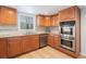 Well-lit kitchen featuring tile floors, granite counters, stainless steel appliances and wood cabinetry at 320 Six Branches Ct, Roswell, GA 30076
