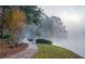 Lake view with lush vegetation, walking path and deer in a foggy landscape at 320 Six Branches Ct, Roswell, GA 30076