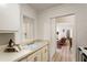 Galley kitchen flowing to the living area, with light countertops and bright white cabinets at 300 Peachtree Ne St # 24F, Atlanta, GA 30308