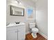 Compact half bathroom with a modern vanity, framed mirror, and a window for natural light at 4312 White Hickory Nw Ln, Kennesaw, GA 30152