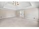 A large bedroom with a tray ceiling, neutral walls and carpeted floors at 4312 White Hickory Nw Ln, Kennesaw, GA 30152