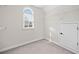 Walk-in closet with an arched window and built in shelving with a white door to the attic at 4312 White Hickory Nw Ln, Kennesaw, GA 30152