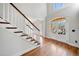 Bright foyer with hardwood floors, a staircase, and a view of the front door and outdoor scenery at 4312 White Hickory Nw Ln, Kennesaw, GA 30152