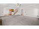 Open-concept living room with carpet, staircase, and views of the kitchen. Lots of space at 4312 White Hickory Nw Ln, Kennesaw, GA 30152