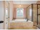 Bathroom featuring tile floor, a soaking tub with a stained-glass window, and a frameless glass shower at 6011 Fairlong Nw Ct, Acworth, GA 30101